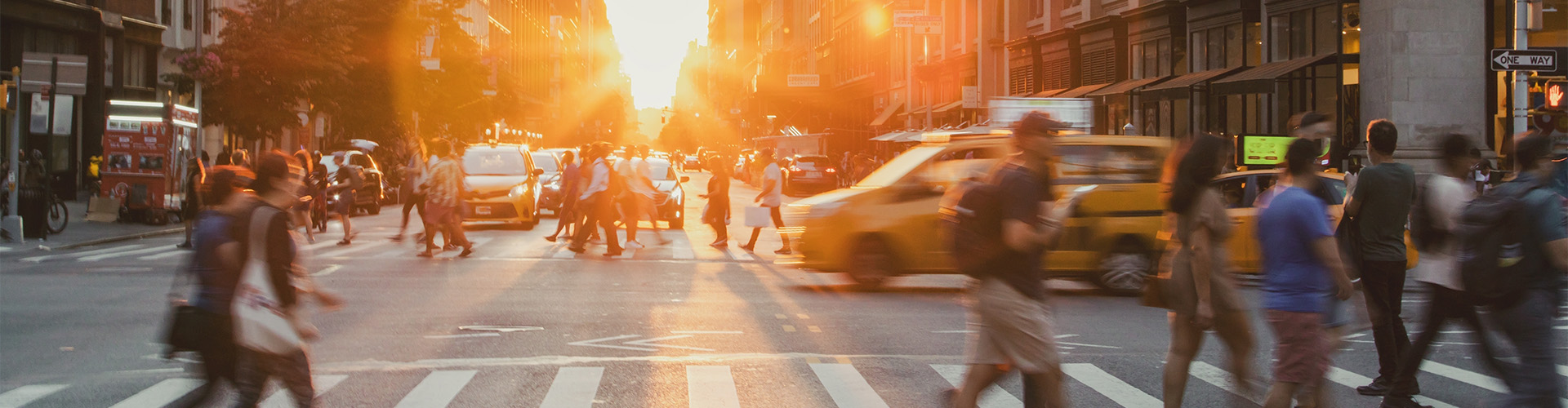 Vielbefahrene Kreuzung in einer Stadt mit verschwommenen Autos und Fußgängern
